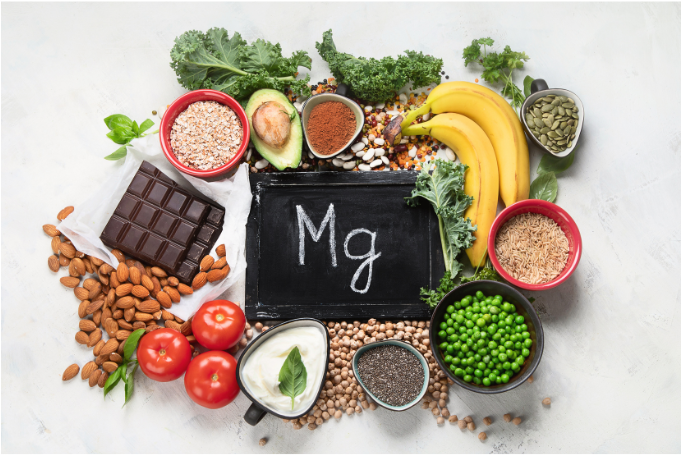 An assortment of magnesium-rich foods including banana, avocado, kale, seeds, nuts, chocolate and tomato, symbolizing the role of dietary and supplemental magnesium in bone healing