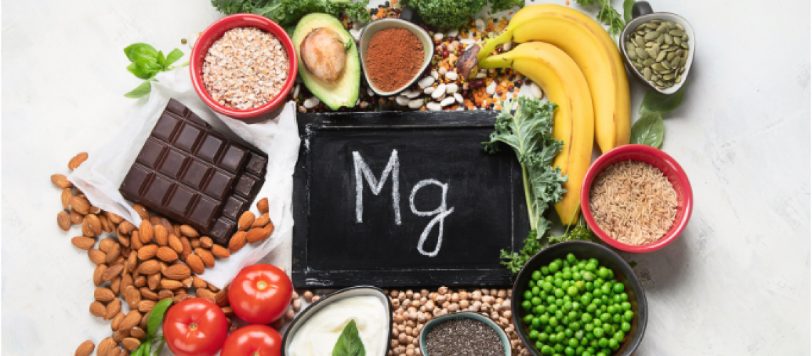 An assortment of magnesium-rich foods including banana, avocado, kale, seeds, nuts, chocolate and tomato, symbolizing the role of dietary and supplemental magnesium in bone healing